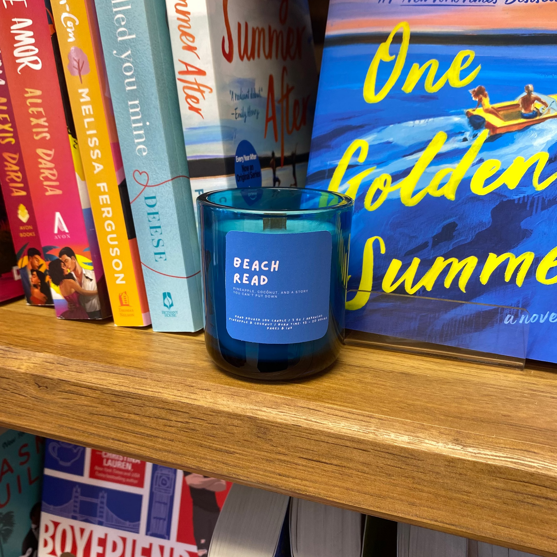 Bookshelf with books and a blue candle labeled 'Beach Read'